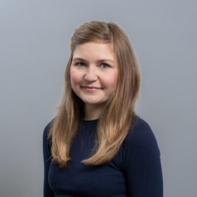 Porträtfoto von Dr. Stefanie Motz, Zahnärztin in der Zahnarztpraxis Stralsund, vor grauem Hintergrund.